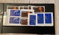 Photo showing multiple Canadian stamps from the 1970s in a black album page.