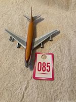 Top-down view of the polished metal 1/200 scale diecast airplane model with orange and silver livery, showing wings and fuselage.