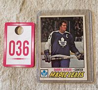 Photo of Darryl Sittler 1977-78 O-Pee-Chee #38 Toronto Maple Leafs hockey card in protective case with lot number tag 036 next to it.