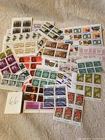 Multiple blocks and sheets of colorful Canadian mint stamps laid out on a surface showing various denominations and designs including nature and Queen Elizabeth II.