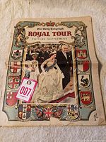 Full view of the cover page of the 1953 Daily Telegraph Royal Tour Picture Supplement showing Queen Elizabeth and other dignitaries with decorative heraldic border.