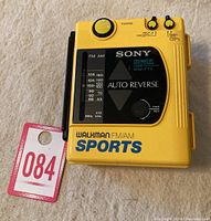Yellow Sony WM-F73 Sports Walkman FM/AM cassette player with tuning dial and radio frequency display.