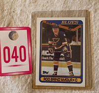 Photo of Rod Brind'Amour rookie hockey card #332 by Topps in a protective plastic sleeve, showing card front with player in St. Louis Blues uniform on ice.