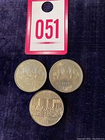 Photo of three Canadian one-dollar coins featuring the 1982 Confederation coin, 1977 Voyageur Dollar, and 1986 Voyageur Dollar.