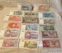 Overview photo showing 18 different Yugoslavian banknotes from the hyperinflation period spread out, highlighting the variety of denominations and designs.