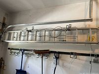 20 foot aluminum extension ladder mounted horizontally on a wall in a garage or storage space.