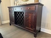 Front view of the sideboard showing three drawers across the top, central lattice wine rack, and two paneled cabinet doors