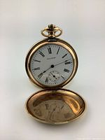 Front view open showing dial with Roman numerals, subsidiary seconds, and inner case lid