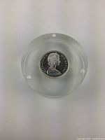 Top view of the silver coin inside clear acrylic block, showing Queen Elizabeth II side with text 'ELIZABETH II D·G·REGINA'.