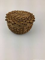 Front angle view of the hand woven basket made of sweetgrass with curled details and detailed lid.