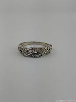 Front view of ring showing vine pattern and diamond accents