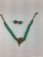 Full view of necklace with double turquoise bead strands and matching earrings above