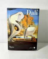Front cover of the hardcover art book showing surreal Dalí artwork and Rizzoli publisher mark.