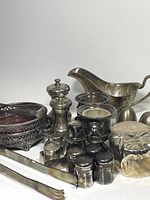 Overview of the silver-plated collection showing multiple items including coasters, salt and pepper shakers, gravy boat, and tongs
