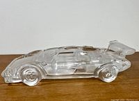 Side view of clear crystal glass Lamborghini car figurine showing streamlined shape, wheels, and rear spoiler.