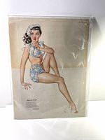 Photo of original 1945 Esquire magazine centerfold featuring a Vargas pin-up girl in blue swimsuit and bonnet sitting pose.