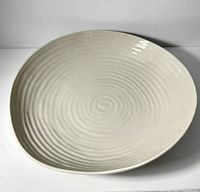 Front angle view of the large ceramic bowl showing the pebble color and spiral interior texture