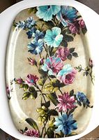 Top view of large vintage fiberglass serving tray showing colorful floral pattern with blue, pink, and purple flowers.