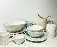Photo of full collection showing various plates, bowls, mugs, jugs, and strainer bowl arranged together