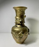 Full front view of vintage Chinese brass vase showing dragon relief wrapping the neck and engraved decorative motifs on body