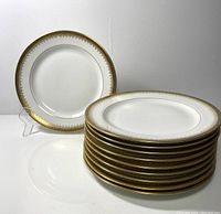 Set of ten white Limoges salad plates stacked with one plate displayed separately showing the full design, including the gold Greek key border.