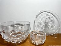 Full set photo showing large bowl, small bowl, and round platter with grape motif in clear textured glass.