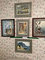 Group shot of all five framed artworks hung on floral wallpaper