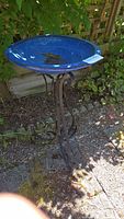 Front view of royal blue glazed ceramic bird bath bowl on wrought iron stand, showing overall condition and color.