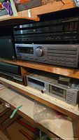 Full view of stacked stereo components including Sony CD player on top, JVC receiver middle, and cassette deck below on shelf