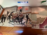 All three woodblock print panels laid side by side on wooden table