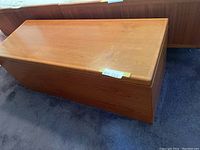 Top and front view of rectangular teak cedar chest with polished finish, showing smooth flat lid and side panels.