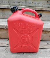 Front view of the red 25 litre gasoline container showing embossed safety warnings and the black cap on top along with the vent cap.