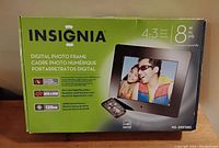 Original box showing brand name Insignia, model NS-DPF118S, screen size 8 inch, aspect ratio 4:3, 800x600 resolution, 128MB internal memory, and USB/SD card compatibility.