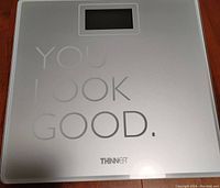 Top view of the Thinner digital bathroom scale showing the phrase 'YOU LOOK GOOD.' and the LCD display.