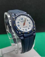 Front view of the Cardinal women's quartz sports wristwatch showing the blue dial with Arabic numerals and yellow minute markers on the bezel, blue rubber strap with textured design.