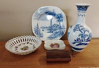 Four vintage ceramic items and one wooden box on a table - includes scenic plate, pierced bowl, vase, trinket holder
