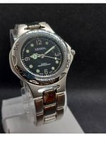 Front view of men's Geneva dive style wristwatch with black dial, silver-tone case, and band, showing functional bezel and dial details.