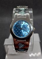 Front view of feminine quartz watch with blue heart-patterned dial and silver-tone band featuring sparkling heart embellishments.