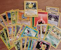 Lot of 33 first edition Pokémon trading cards, showing various Pokémon and Trainer cards arranged in a fan and pile format, including Pikachu, Rhyhorn, Zubat, Totodile, and multiple Trainer and Energy cards.