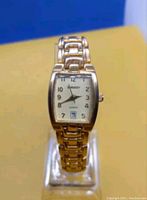 Front view of the women's Gruen Embassy wristwatch showing the gold-tone link bracelet, light-colored face with Arabic numerals, and date display at 6 o'clock.