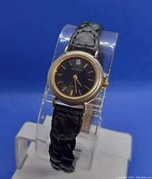 Front view of the women's vintage Helbros watch featuring a black dial, gold-tone bezel, and black braided leather strap.