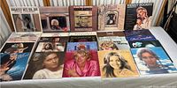 Front view showing 15 vinyl LP records with visible album covers including Kenny Rogers and Dolly Parton among others, placed in two rows on a white surface.