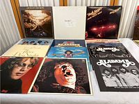 Image showing multiple classic rock vinyl records from various artists including Jackson Browne, Alabama, Three Dog Night, and Bob Seger, all arranged standing and overlapping on a chair.