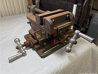 Front angle view showing the vise with metal handles and the jaw assembly resting on a table.