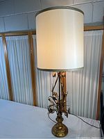 Full view of the tall table lamp with cream fabric shade showing overall shape and height.