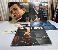 Overview photo of 5 Johnny Cash vinyl records laid out, showing album covers and some text details.