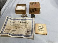 Overall view showing two rock samples, certificate of authenticity, fault manual booklet, and original cardboard box packaging.