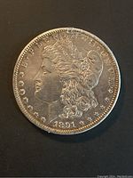 Obverse side of the 1891 Morgan silver dollar showing Lady Liberty profile, with inscription and date visible.