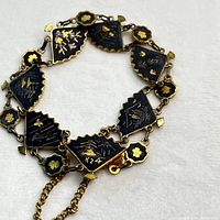 View of the full vintage bracelet with multiple black and gold plated linked sections showing intricate Japanese designs.