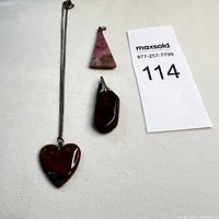 Three natural stone pendants shown including one heart shape on chain and two different shapes without chains.